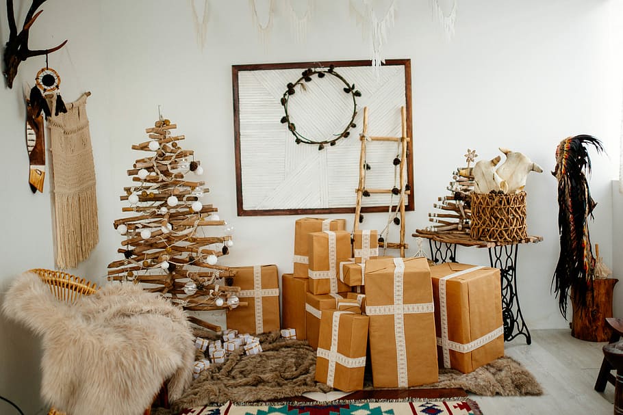 brown cardboard brown beside brown Christmas tree inside room during daytime, brown cardboard boxes and tree decor