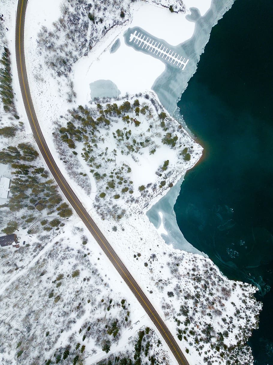 aerial photograph of forest, aerial photography of road near body of water covered with snow HD wallpaper