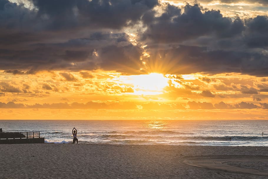 woman doing yoga while in seashore during sunset, person doing yoga exercise on shore during sunset HD wallpaper