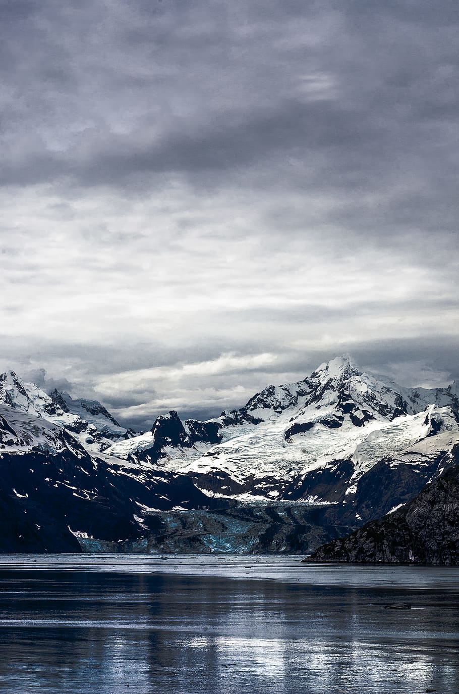 calm lake water near snowy mountain peak under cloudy skies, white and black mountain HD wallpaper