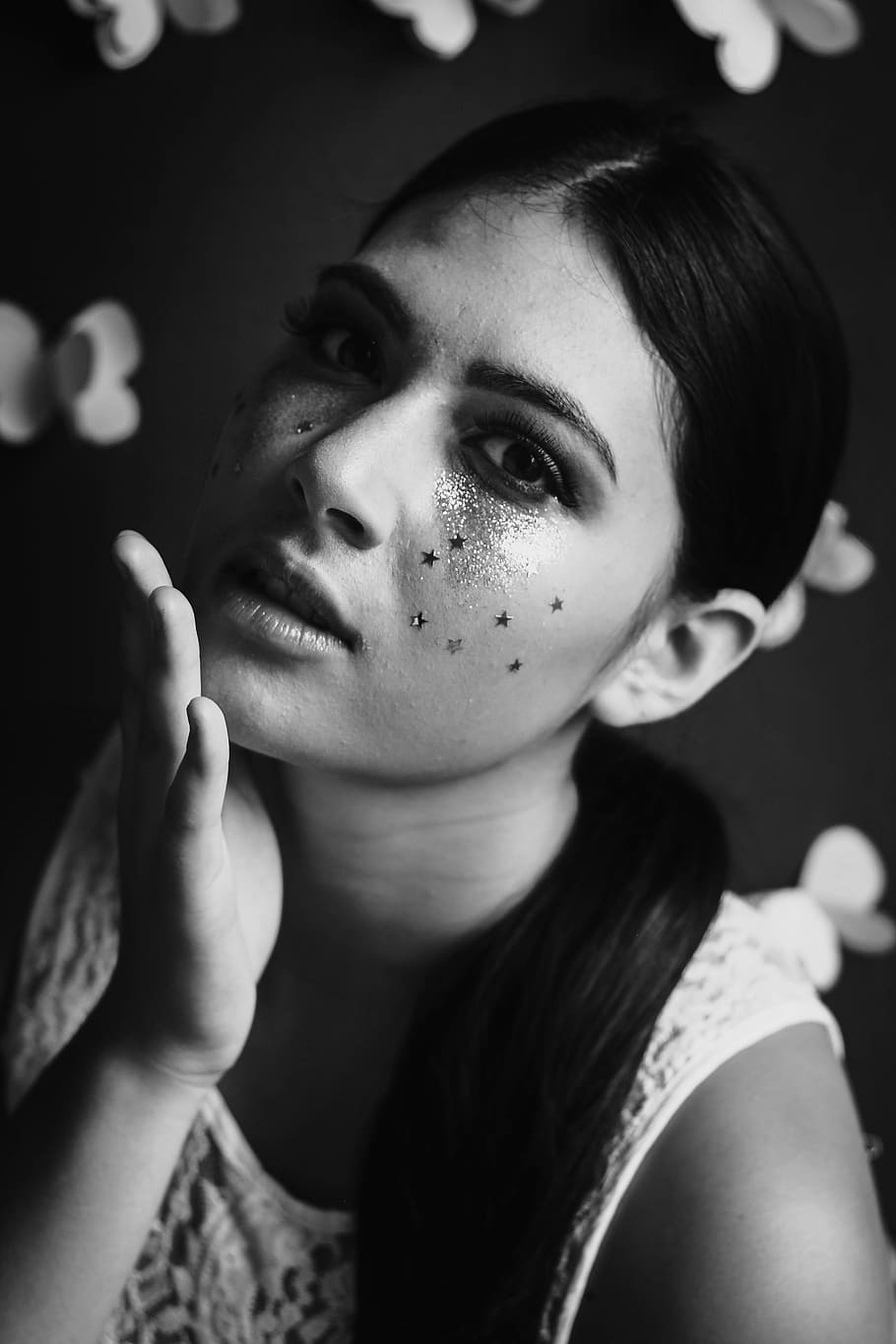 Black and white shot of attractive woman with dark hair and face glitter, grayscale photo of woman in white sleeveless top with face paint HD wallpaper