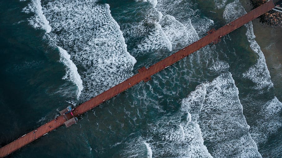 aerial photography of clear blue sea, waves of body of water and brown dock during daytime HD wallpaper