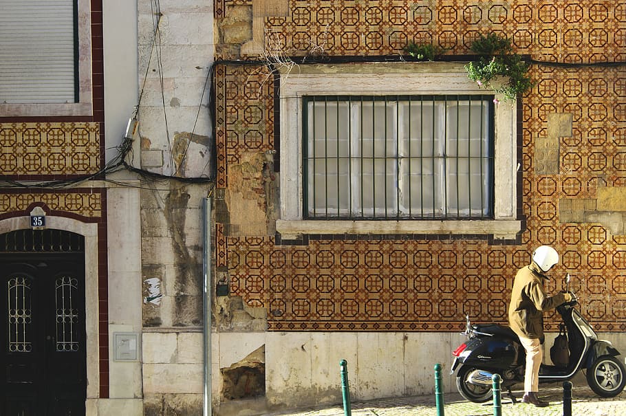 man riding motorcycle beside building during day, man riding on motor scooter beside house HD wallpaper