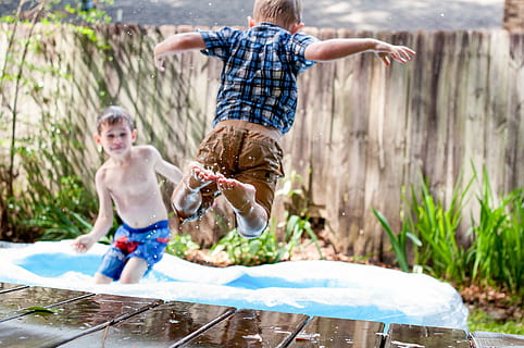 two boys playing in inflatable pool during daytime, two boys playing on inflatable pool outside during daytime HD wallpaper
