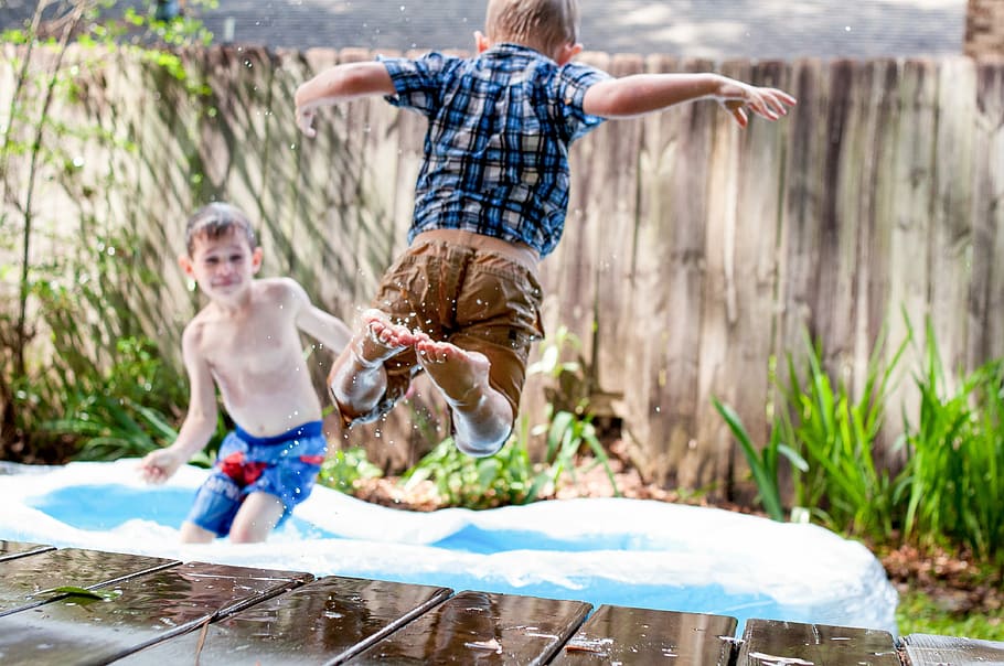 two boys playing in inflatable pool during daytime, two boys playing on inflatable pool outside during daytime HD wallpaper
