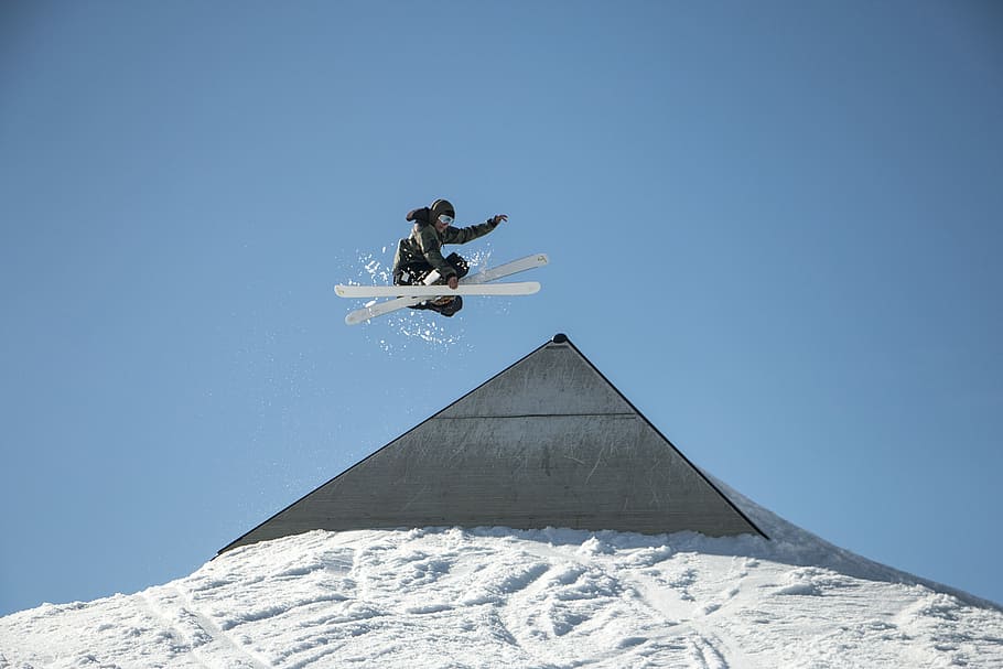 person playing ski at daytime, person on air skiing above snow covered slope HD wallpaper