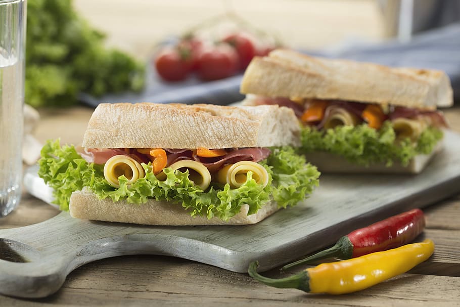 sandwich with lettuce and cheese served on chopping board, sandwiches served on wooden tray