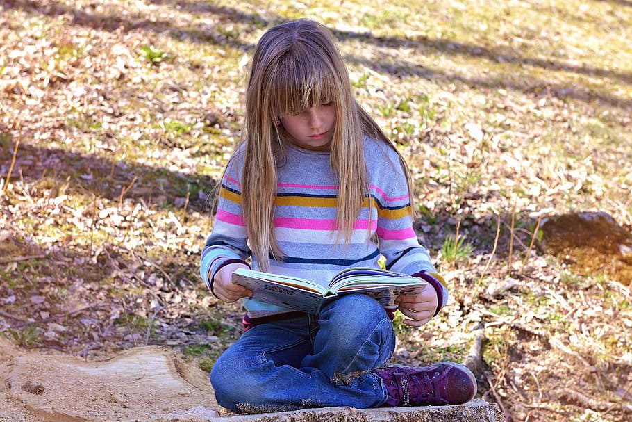 girl reading book sitting on green grass at daytime, human, child, HD wallpaper