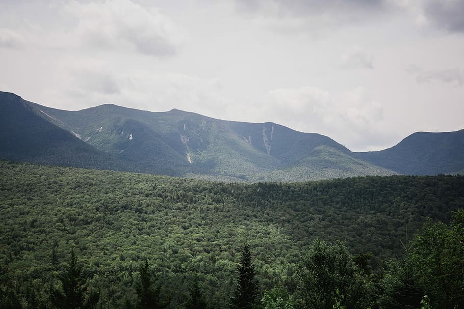 green and black mountains under white and gray sky at daytime, landscape photography of green leafed trees surrounded by mountains HD wallpaper