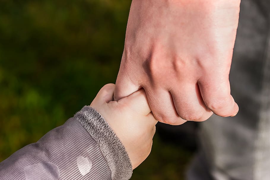 person holding child's hand, hands, toddler hand, small fist