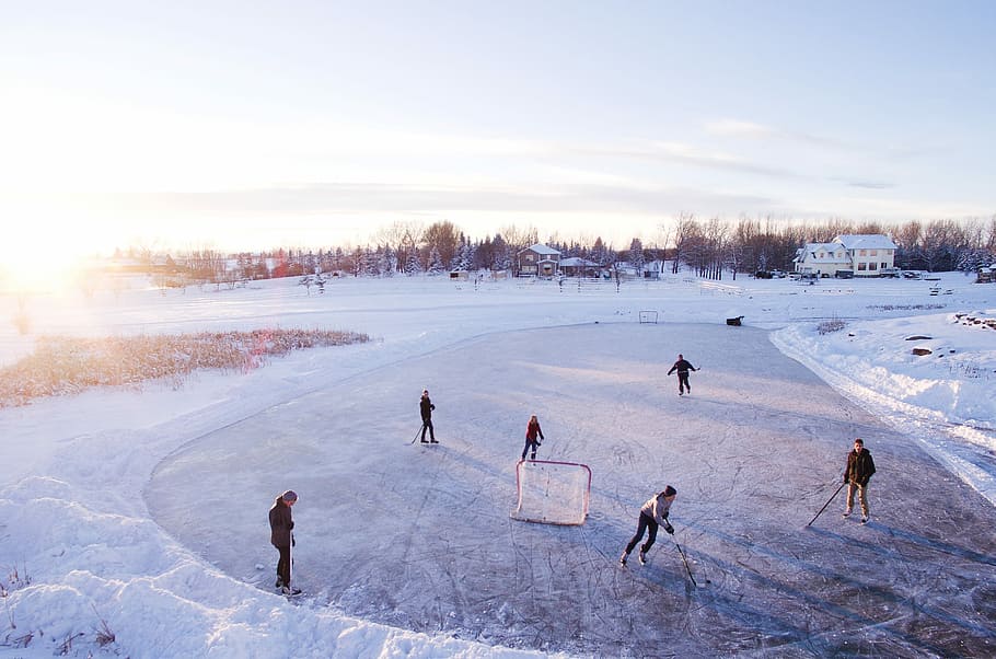 group of people playing outdoor hockey during winter, group of people playing hockey