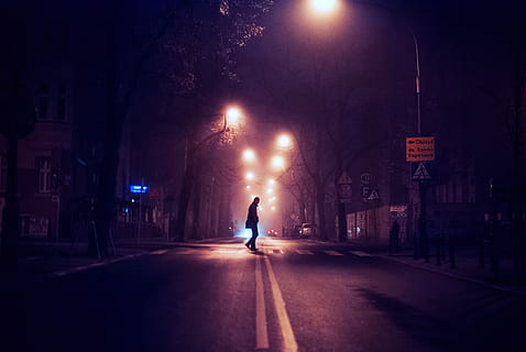 person standing on center asphalt road, silhouette of man crossing on pedestrian lane during nighttime HD wallpaper