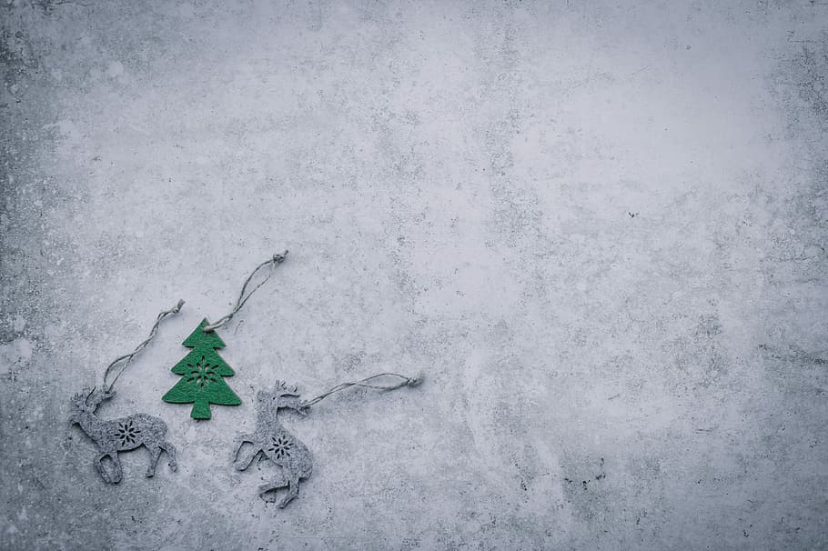 Christmas flatlay with blank space, three gray and green deer and pine tree ornaments HD wallpaper