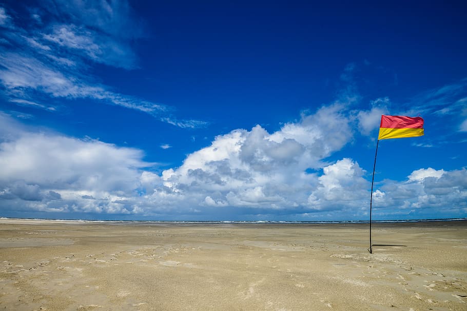 red and yellow flag, beach, sky, blue sky, cloud - sky, sand HD wallpaper