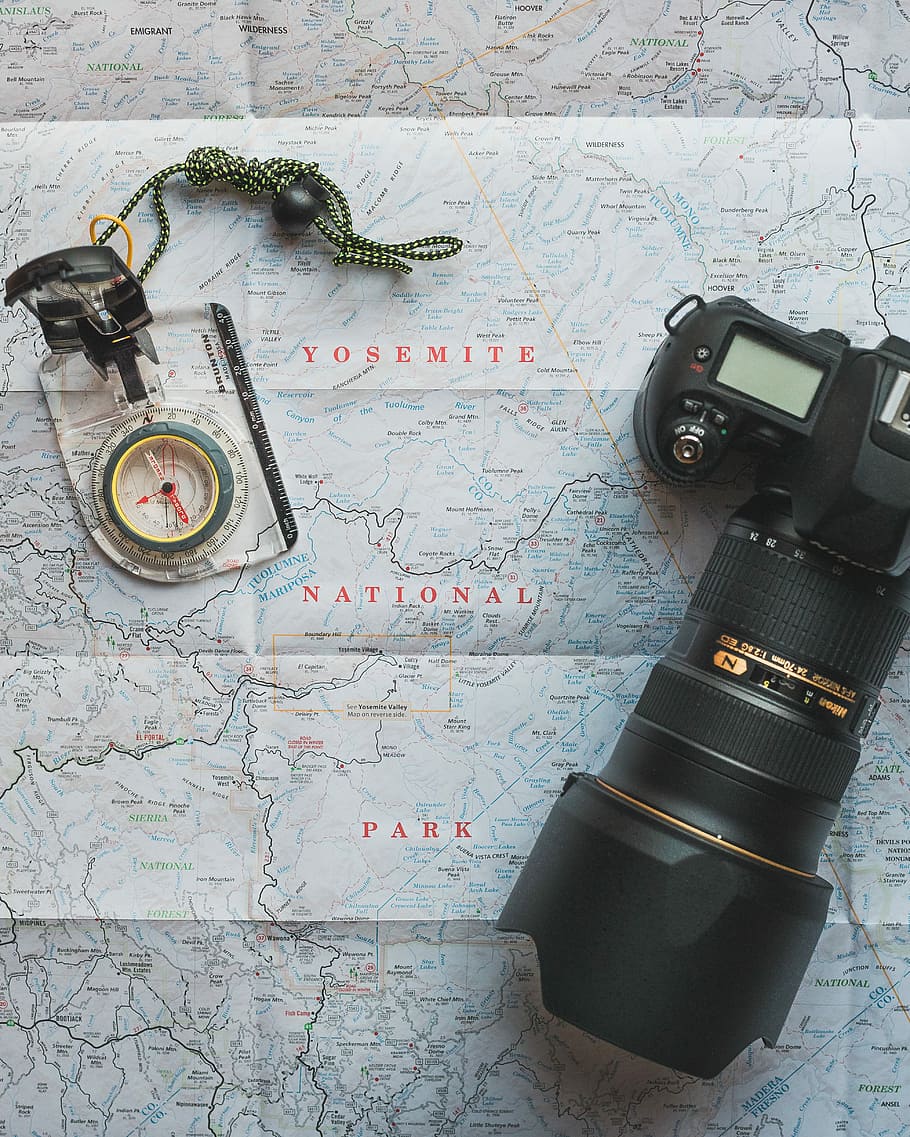 black Nikon DSLR camera beside of map compass, black DSLR camera on top of map HD wallpaper