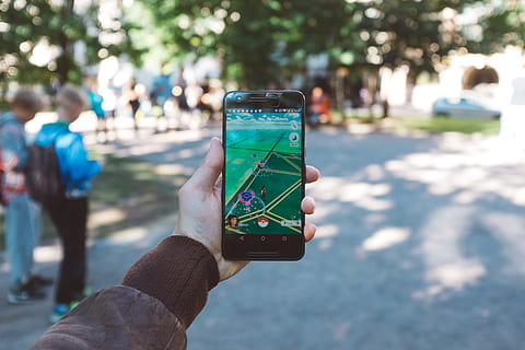 Royalty-Free photo: Person holds smartphone with Pokemon Go application  running