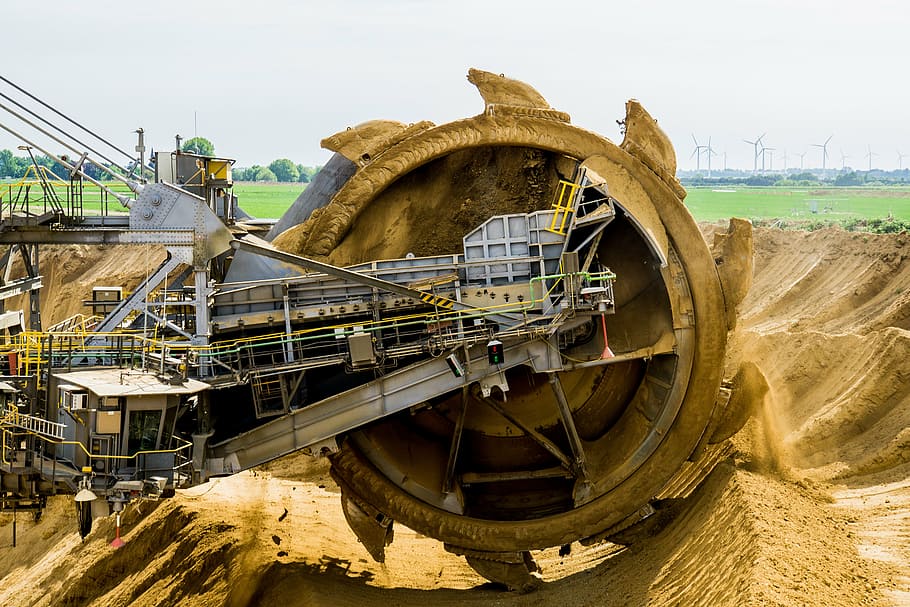 gray industrial machine at cultivates sand at daytime, paddle wheel