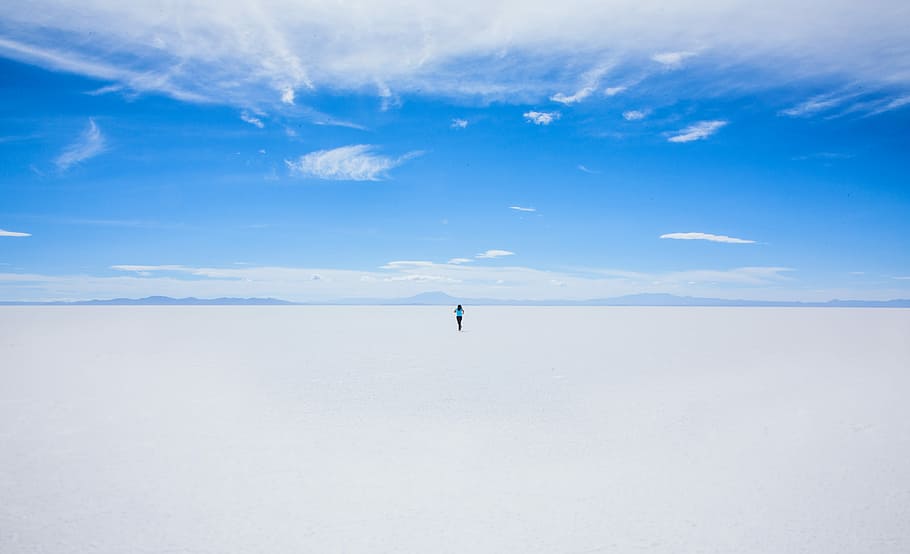 person walking of sand covered field during daytime, man walking on snowfield during daytime HD wallpaper