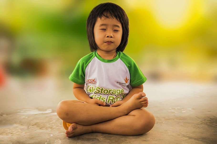 girl wearing white and green crew-neck shirt, meditating, mediation