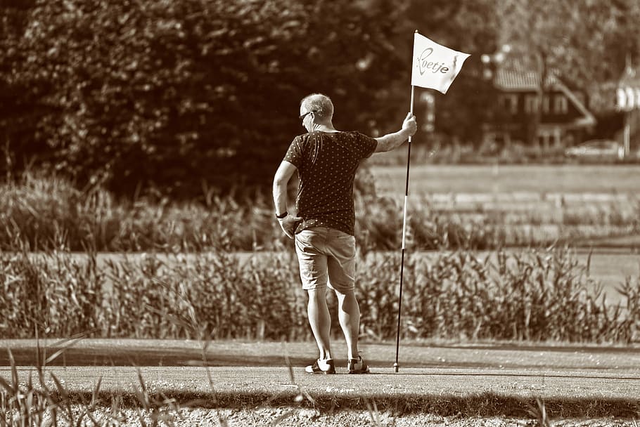 man standing beside flagpole, person, golfer, golf course, sport, HD wallpaper