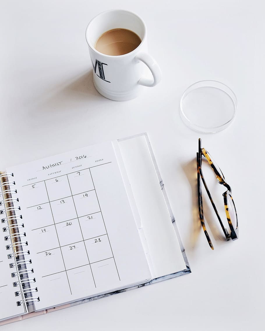 white ceramic mug beside monthly planner notebook, calendar HD wallpaper