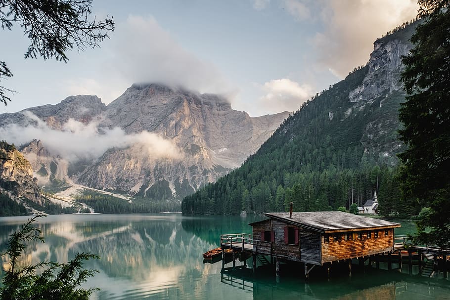 body of water and mountains painting, banana trees, cabin, clouds HD wallpaper