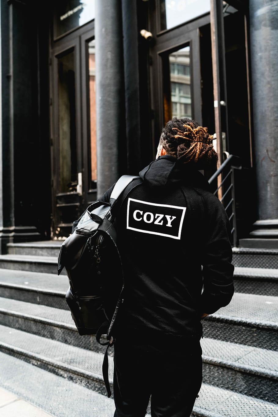 person wearing hoodie and standing beside the building, person wearing black jacket standing near building HD wallpaper