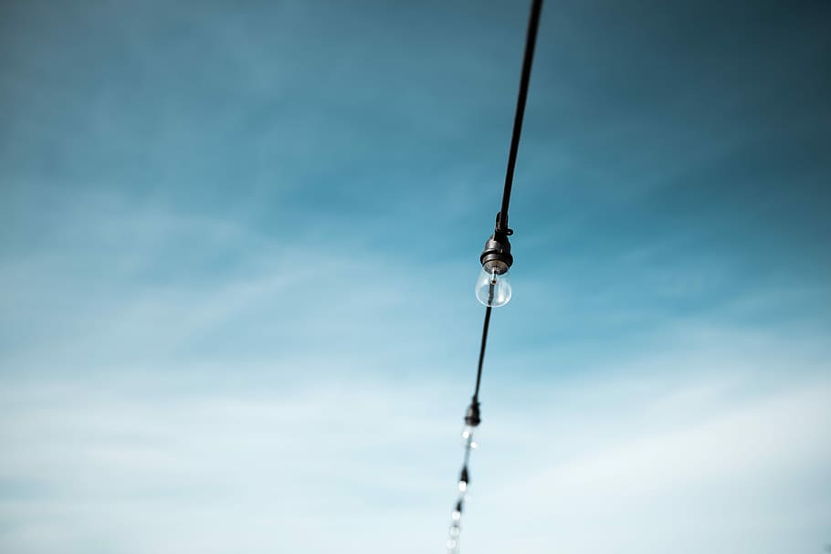 photo of string bulb light, focus photography of clear LED bulb on string under white and white sky at daytime HD wallpaper
