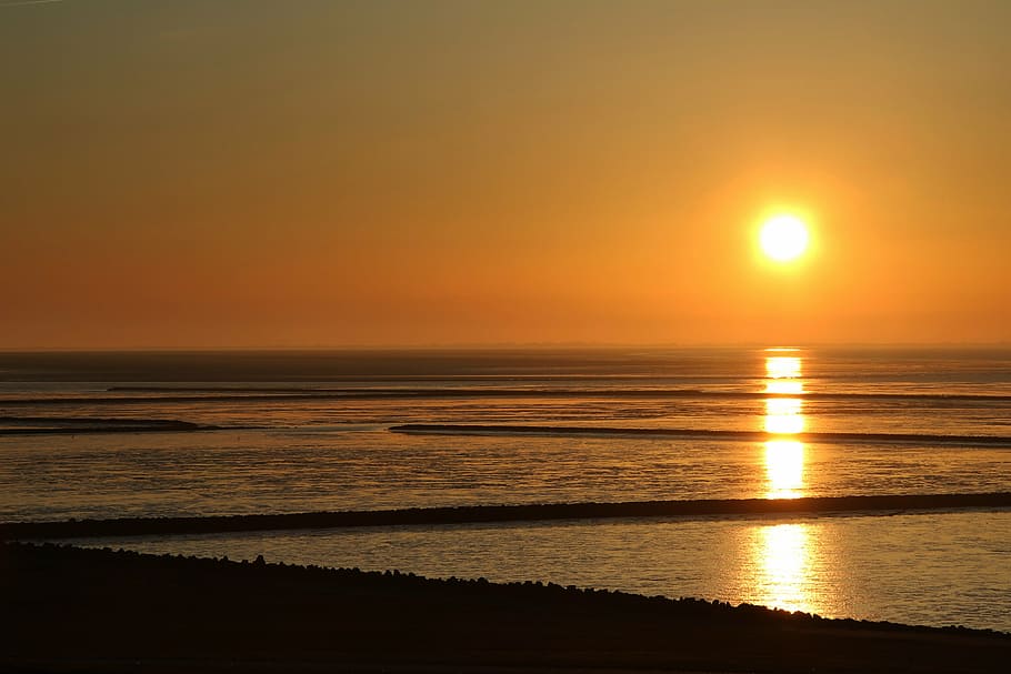 sun above body of water during sunset, wadden sea, north sea