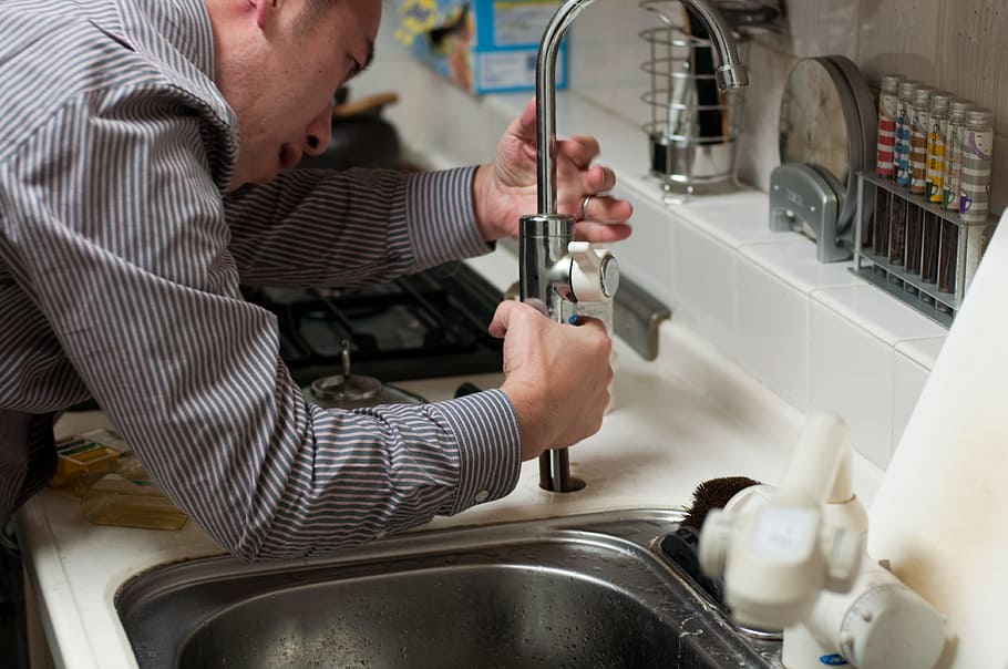 man fixing stainless steel faucet, plumber, handyman, repair
