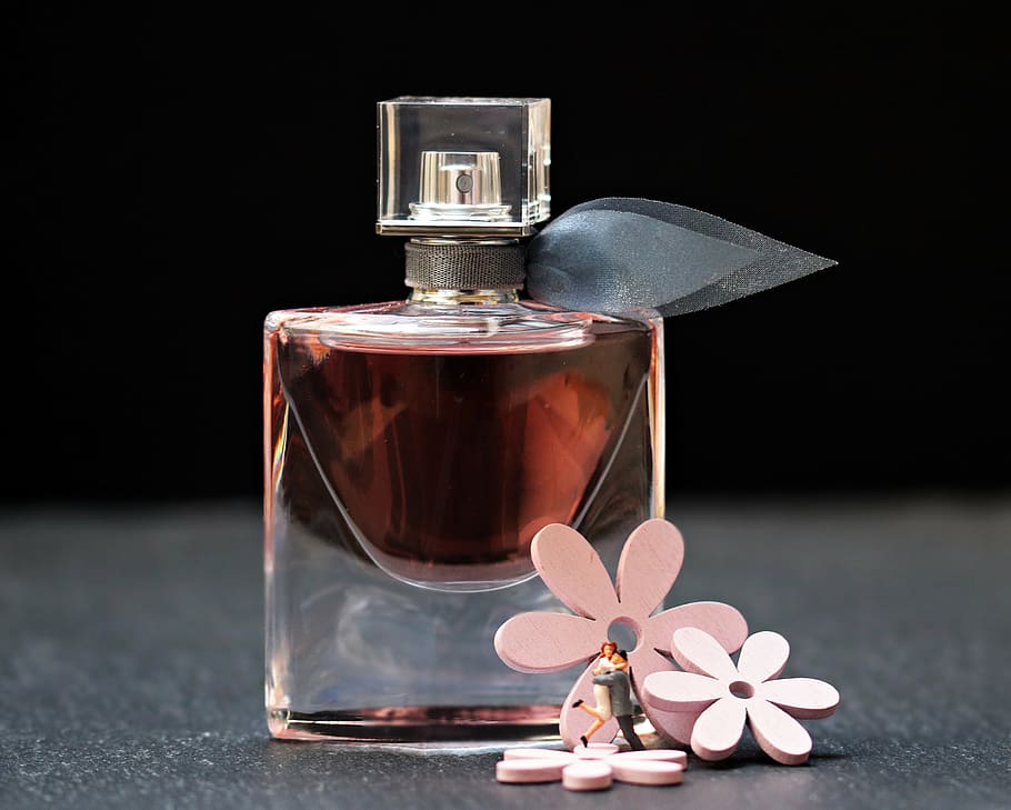 fragrance bottle beside three pink petaled flowers, perfume, flacon