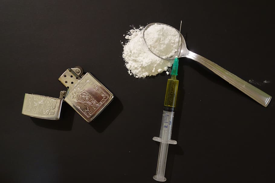 clear syringe beside silver flip lighter, drugs, addict, addiction