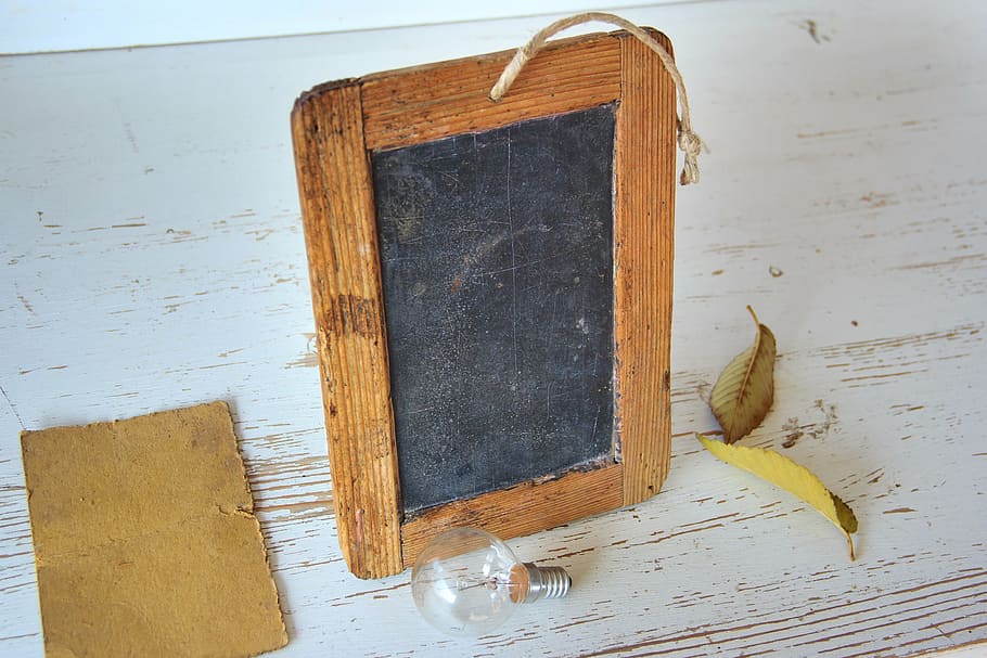 brown and black wooden photo frame near glass halogen bulb, school
