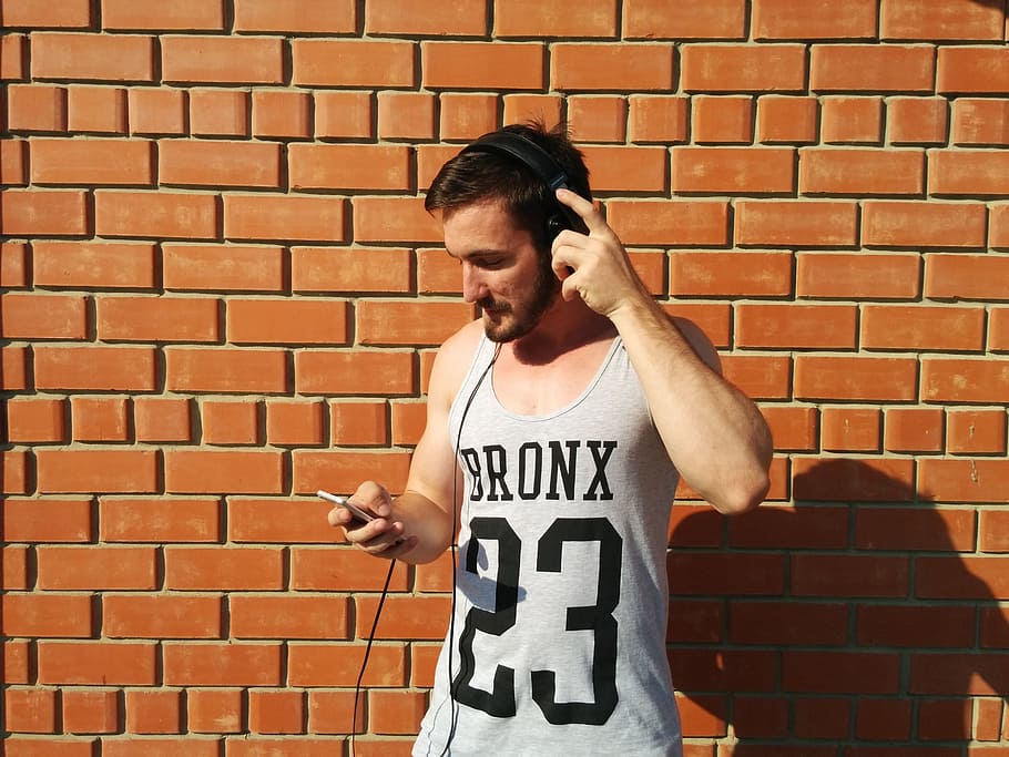 man using smartphone beside brick wall, young, music, player HD wallpaper