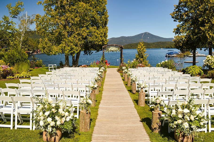 white folding chair in front of body of water, wedding reception next to sea water