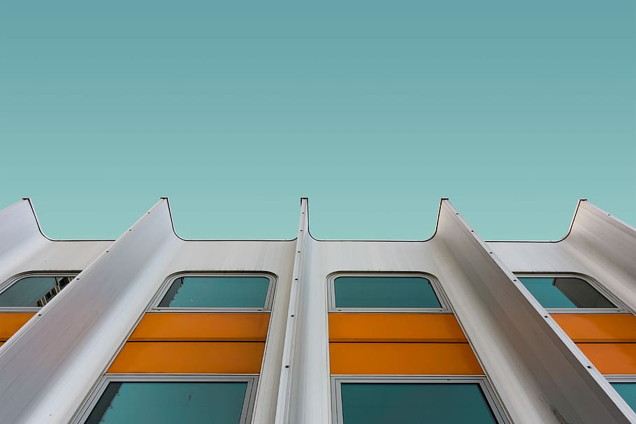 low angle photo of white and orange structure, gray and orange high-rise building during daytime HD wallpaper