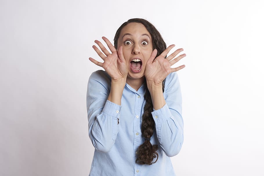 woman wearing blue long-sleeved button-up shirt, excited, surprised