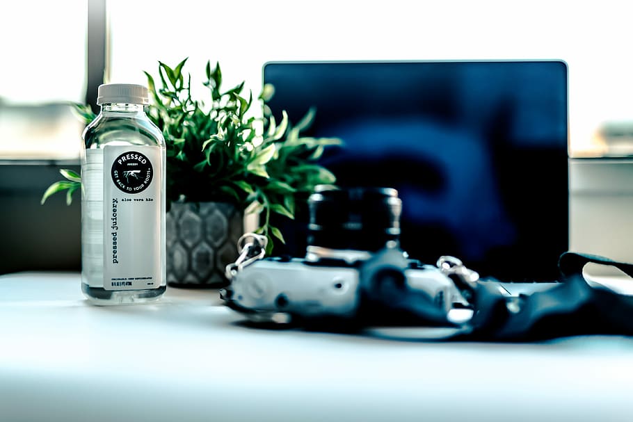 clear glass bottle, selective focus photo of bottle near monitor HD wallpaper