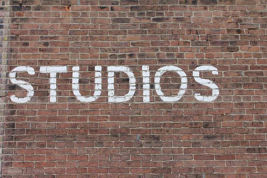 Studios text on brown brick wall, Studios print on brick wall HD wallpaper