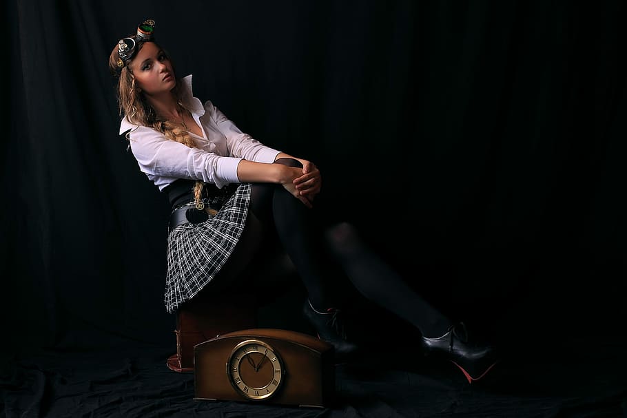 selective color photography of woman wearing white collared long-sleeved shirt and skirt sitting on brown wooden clock HD wallpaper