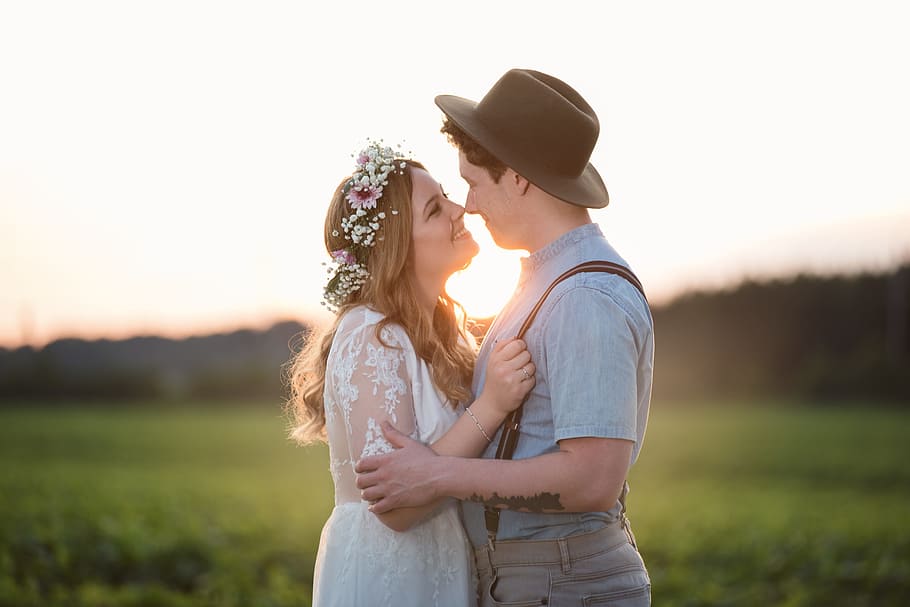 couple facing each other with green grass background \, couple about to kiss near grass field