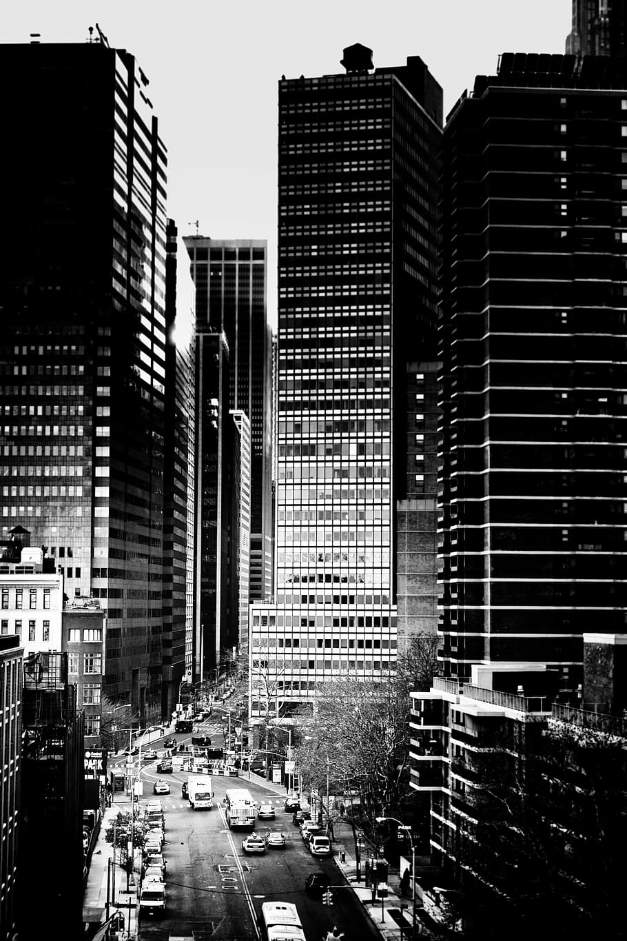 grayscale photo of cars on highway near high rise building over sky HD wallpaper
