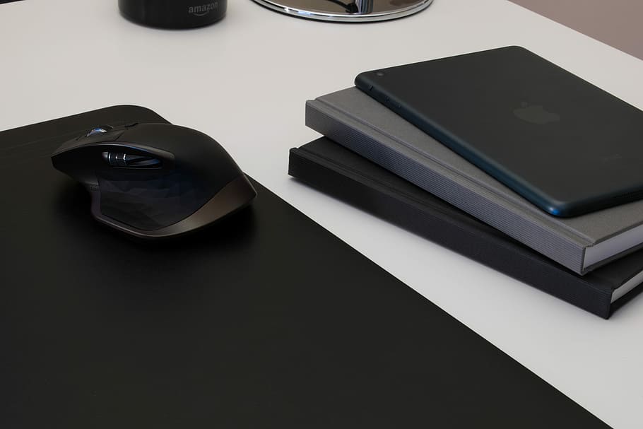 black and gray cordless mouse on black mousepad near black and gray books, black cordless computer mouse beside the DVD case HD wallpaper