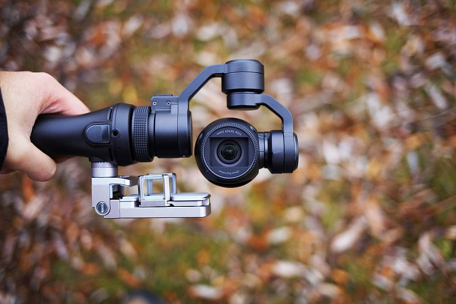 person holding black tripod with camera, person holding black selfie stick HD wallpaper