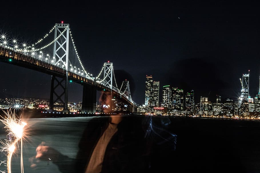 photo of San Francisco Golden Gate, man holding sparklers, bridge