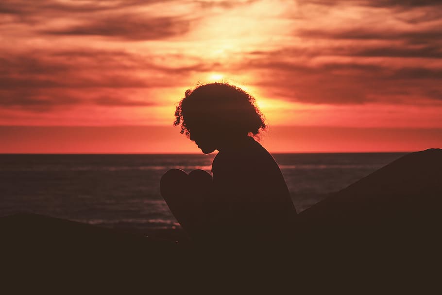 silhouette of girl sitting near sea during golden hour, silhouette of woman sitting near body of water during sunset HD wallpaper