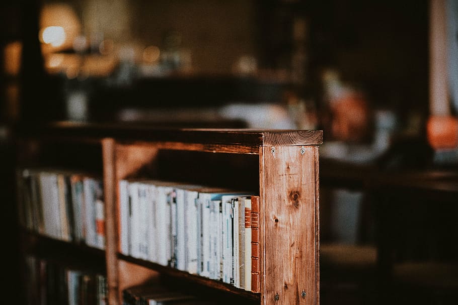 brown wooden bookcase with arranged books selective focus photography HD wallpaper