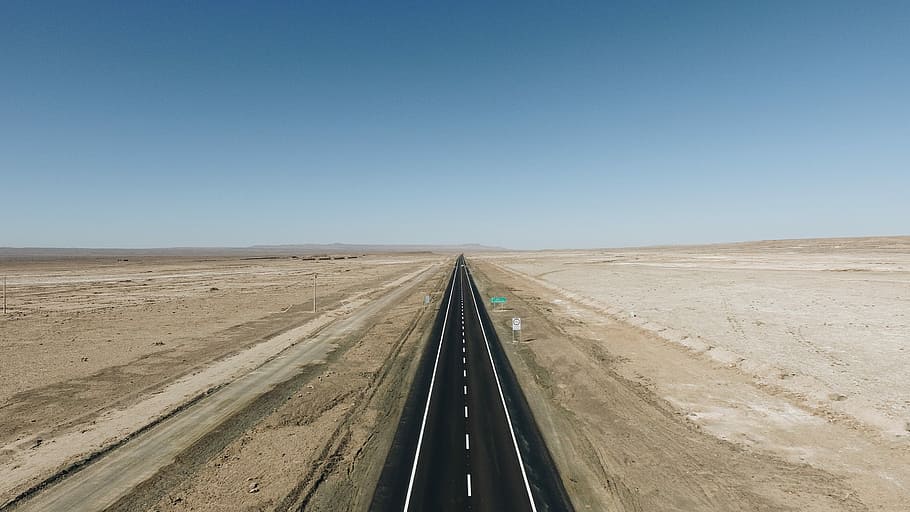 top view of asphalt road, road between desert under blue sky HD wallpaper