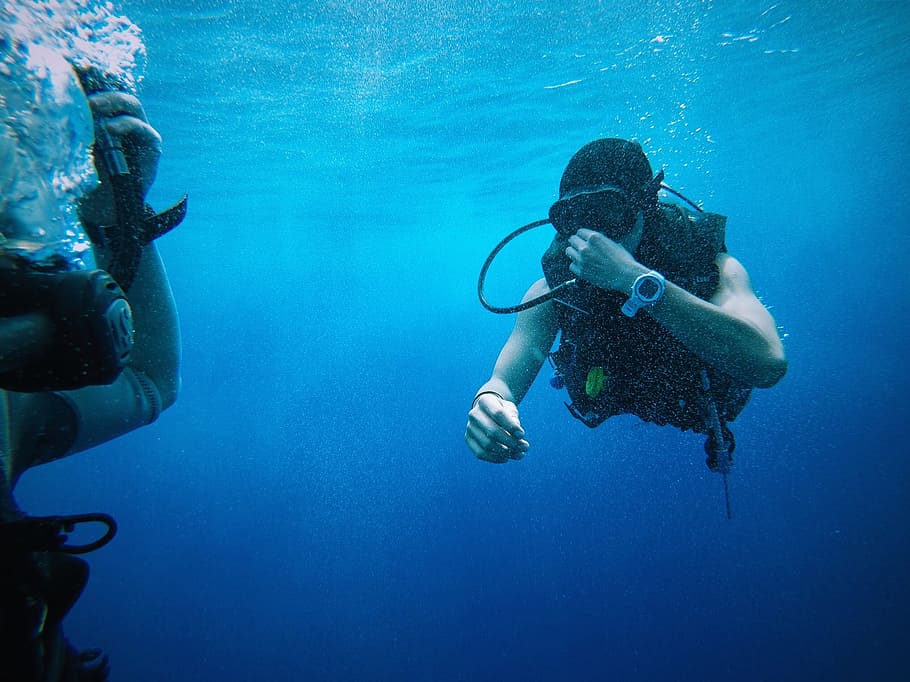 person scuba diving underwater, blue water, divers, equipments