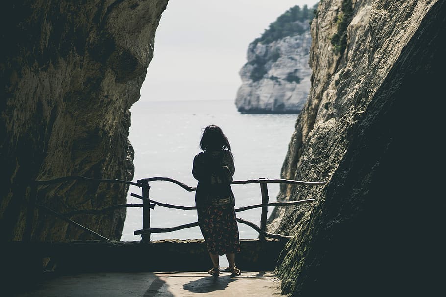 woman looking at sea, woman standing in the middle of stones HD wallpaper